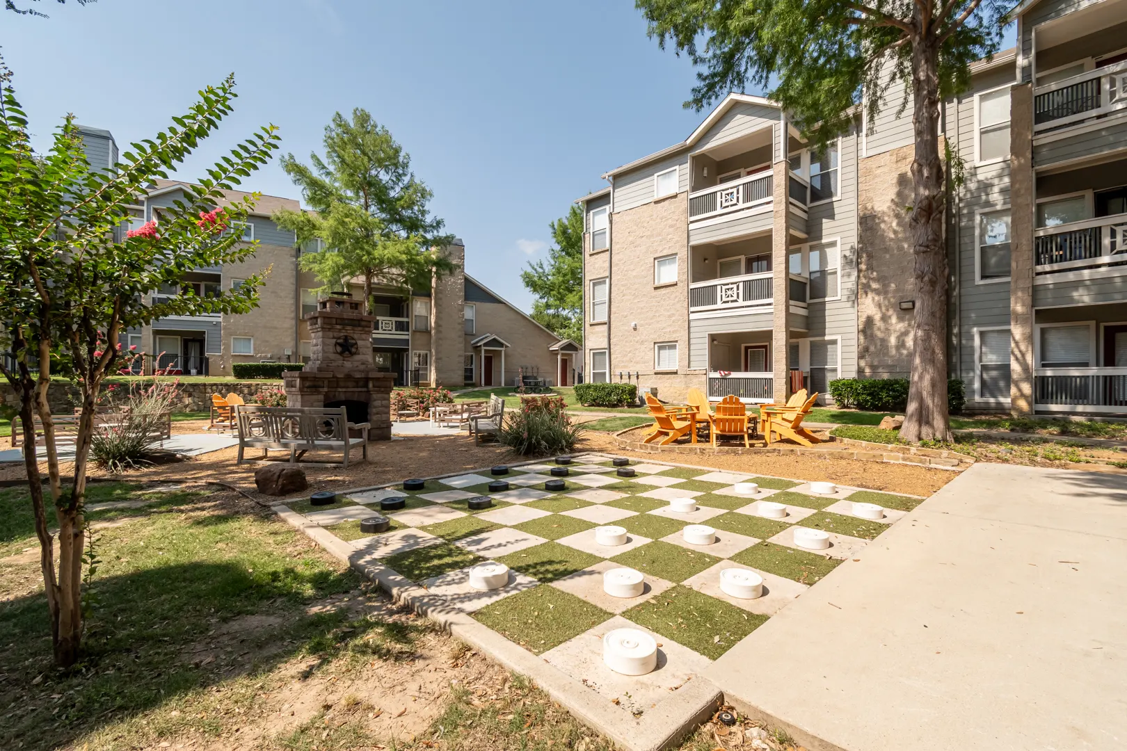 Outdoor stone fireplace and social patio at Western Station at Fossil Creek in Fort Worth, Texas